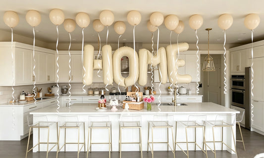 Bright white modern kitchen decorated with cream HOME letter balloons for housewarming celebration, practical new home gift inspiration