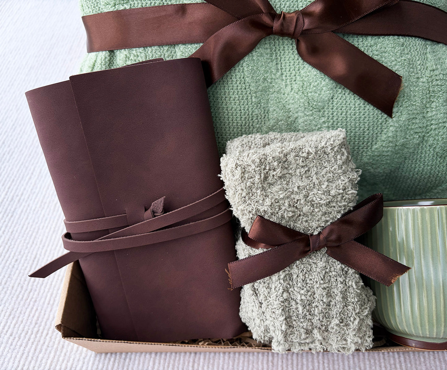 Minimal Sage Green Cozy Gift Box for Her | Cable Knit Blanket, Ribbed Sage Mug, Fuzzy Socks & Leather Journal Gift Basket komorebi INC