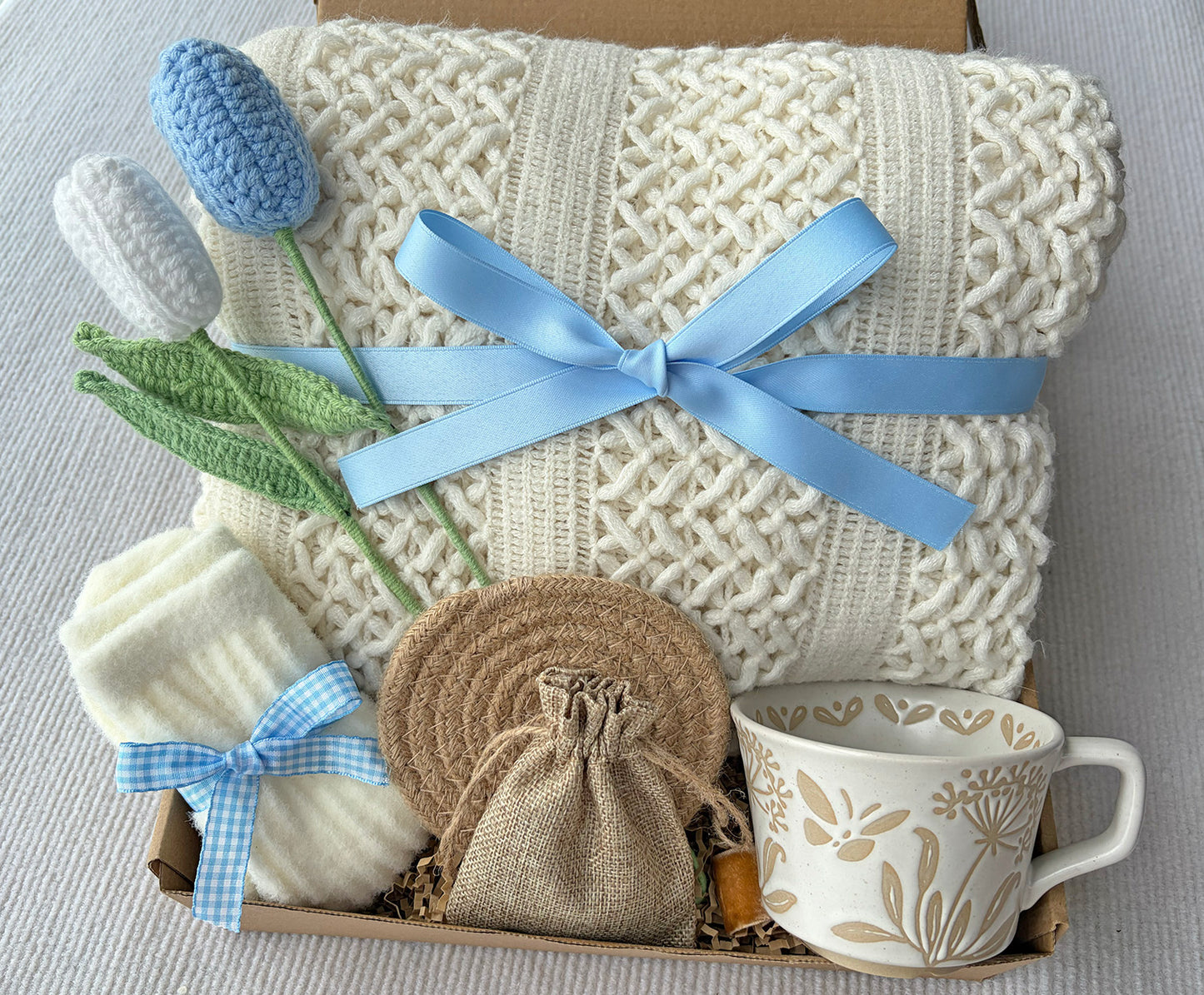 Cream Sky Blue Cozy Gift Basket for Her – Self Care Gift Box with Knit Blanket, Botanical Mug, Fuzzy Socks, Scented Sachet & Crochet Tulips komorebi INC